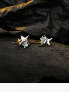 Close-up of S925 sterling silver star stud earrings with bicolor gold finish and blue stones.