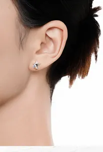Close-up of a stylish S925 sterling silver two-tone star stud earring on the ear