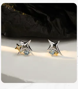 Detailed view of S925 sterling silver star stud earrings with two-tone finish and blue gems