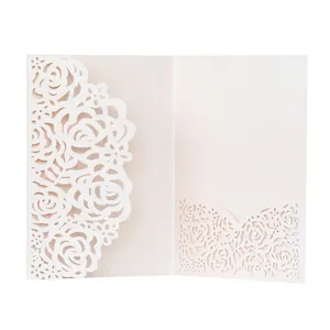 Intricate laser-cut rose pattern detail on a light pink wedding invitation card