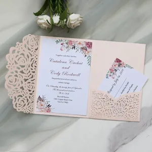 Detail of laser-cut wedding invitation card with pink floral design and RSVP insert