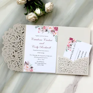 Close-up of elegant laser-cut floral wedding invitation with pink flower printing.