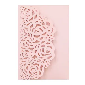 Intricate pink laser-cut rose pattern on an elegant wedding invitation card detail.
