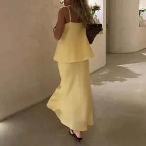 Elegant pale yellow camisole and maxi skirt set shown from a stylish rear view angle.