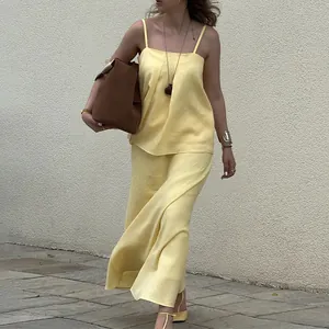 Elegant pale yellow two-piece set with a camisole top and matching maxi skirt.