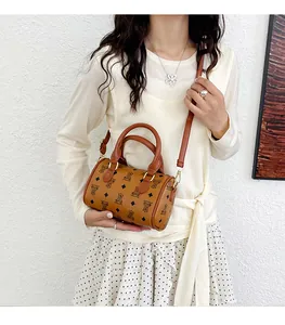 Lifestyle detail of a cute bear pattern barrel handbag worn as a stylish crossbody.