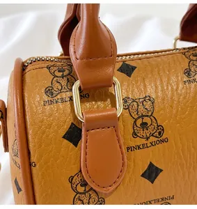 Close-up of golden metal ring connector on brown bear patterned handbag
