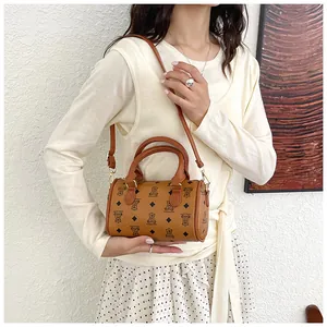 Stylish brown barrel bag with bear pattern worn by model in light academy outfit