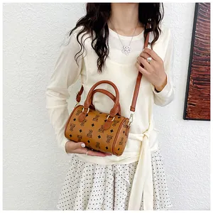 Detail view of a stylish brown mini boston bag with cute bear patterns on a model