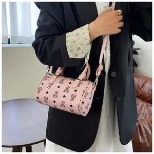 Close-up of pink cylindrical crossbody bag featuring bear and diamond pattern detail