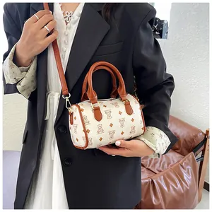 Detail view of a stylish mini Boston bag with cute bear pattern and brown leather straps