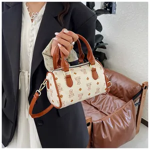 Elegant cylindrical crossbody bag featuring a cute bear pattern and stylish brown trim