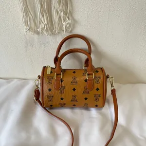 Close-up of a brown Boston bag featuring cute bear prints and gold-tone hardware