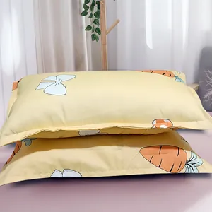 Pair of yellow pillowcases with cute carrot and bow patterns in a bedroom setting