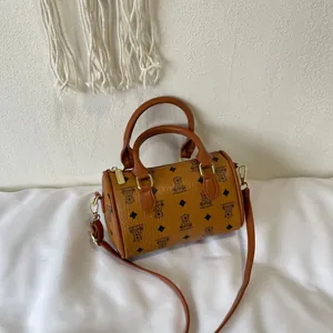 Vintage brown barrel bag with bear monogram print, dual top handles, and gold hardware