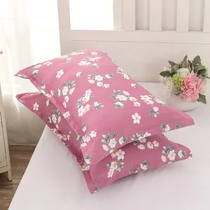 Modern pair of pink floral pattern pillowcases displayed on a white bed with flowers