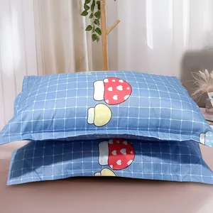 Close-up of blue grid pillowcase featuring adorable red and yellow cartoon mushroom patterns
