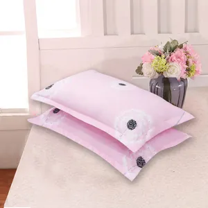 Detail view of soft pink pillowcases with elegant white dandelion print patterns.