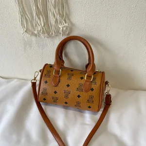 Stylish brown barrel bag featuring cute bear prints and a detachable shoulder strap.