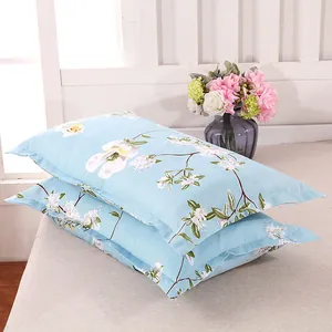 Detailed view of light blue floral pattern pillowcases stacked on a neutral bed surface.