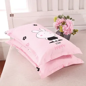 Pair of pink pillowcases with cute bunny cartoon design and Love Happy text print on bed