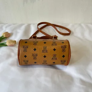 Close-up view of a brown barrel crossbody bag featuring a cute bear print pattern