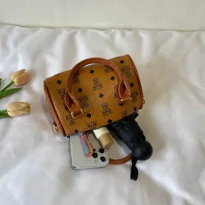 Close-up detail view of the brown barrel handbag with bear pattern and daily items inside