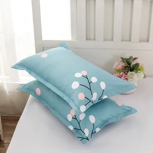 Pair of modern minimalist blue floral pillowcases on a white bed setting.