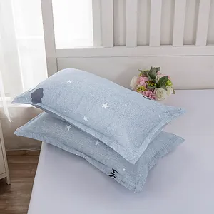 Close-up of a pair of light blue pillowcases with minimalist star and cloud patterns