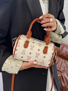Fashionable cream-colored Boston bag featuring a cute brown bear pattern and handles