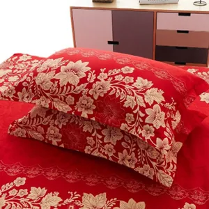Detail view showing a pair of red floral print pillowcases on a matching red bed sheet