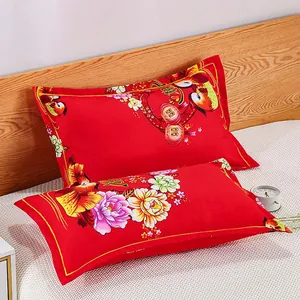 Detailed view of red festive pillowcases with traditional Chinese floral and wedding motifs.
