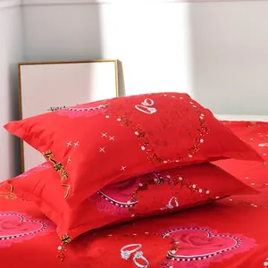 Close-up detail of romantic red pillowcase set with heart and ring wedding patterns