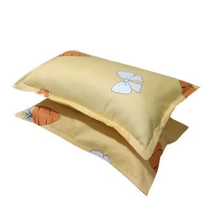 Pair of soft yellow pillowcases with cute carrot and ribbon print for home or dormitory