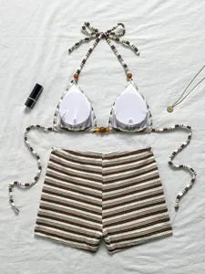 Dettaglio di alta qualità di un bikini a due pezzi a righe marroni con pantaloncini boy-leg
