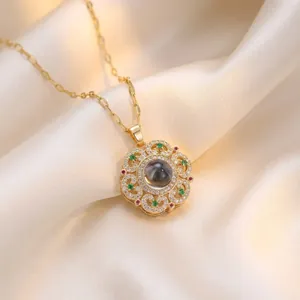 Elegant flower pendant necklace with green emerald zircons on soft cream silk background