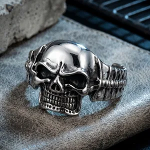 Detailed macro view of a punk-style stainless steel skull cuff bracelet for men.