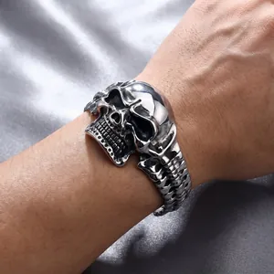 Close-up view of a men's stainless steel punk skull bracelet worn on a wrist.