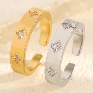 Detailed close-up of gold and silver stainless steel rings with zircon flower pattern