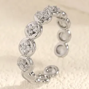 Close-up of a silver stainless steel adjustable ring with zircon flower settings.