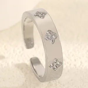 Close-up of a silver stainless steel ring featuring three zircon flower motifs