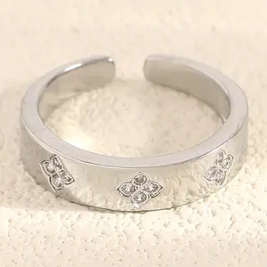 Macro shot of silver stainless steel open ring with sparkling zircon clover patterns
