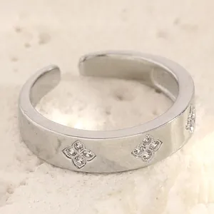 Macro detail of a silver stainless steel open ring featuring zircon stone flower patterns