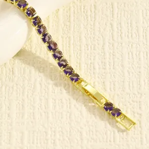 Dettaglio ravvicinato di un bracciale tennis placcato oro con eleganti gemme viola