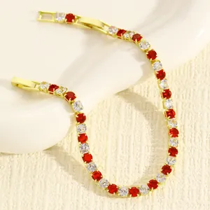 Dettaglio di un elegante bracciale tennis dorato con pietre rosse e bianche luccicanti