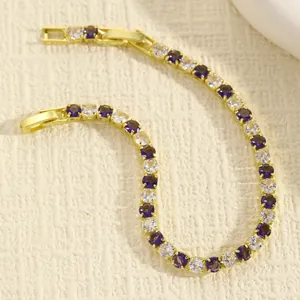 Vista dettagliata di un elegante bracciale tennis dorato con pietre viola e bianche tonde