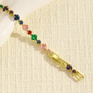 Dettaglio macro di un bracciale dorato con pietre di zircone quadrate multicolori