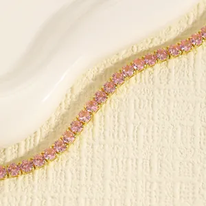 Primo piano di un elegante braccialetto tennis con strass rosa e montatura a griffe oro
