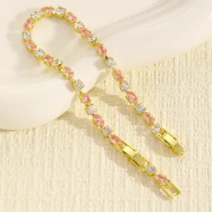 Dettaglio di un bracciale dorato con cristalli a forma di marquise rosa e trasparenti