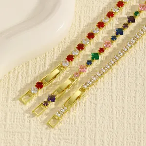 Dettaglio macro di tre bracciali tennis dorati con vivaci pietre di zirconia cubica.